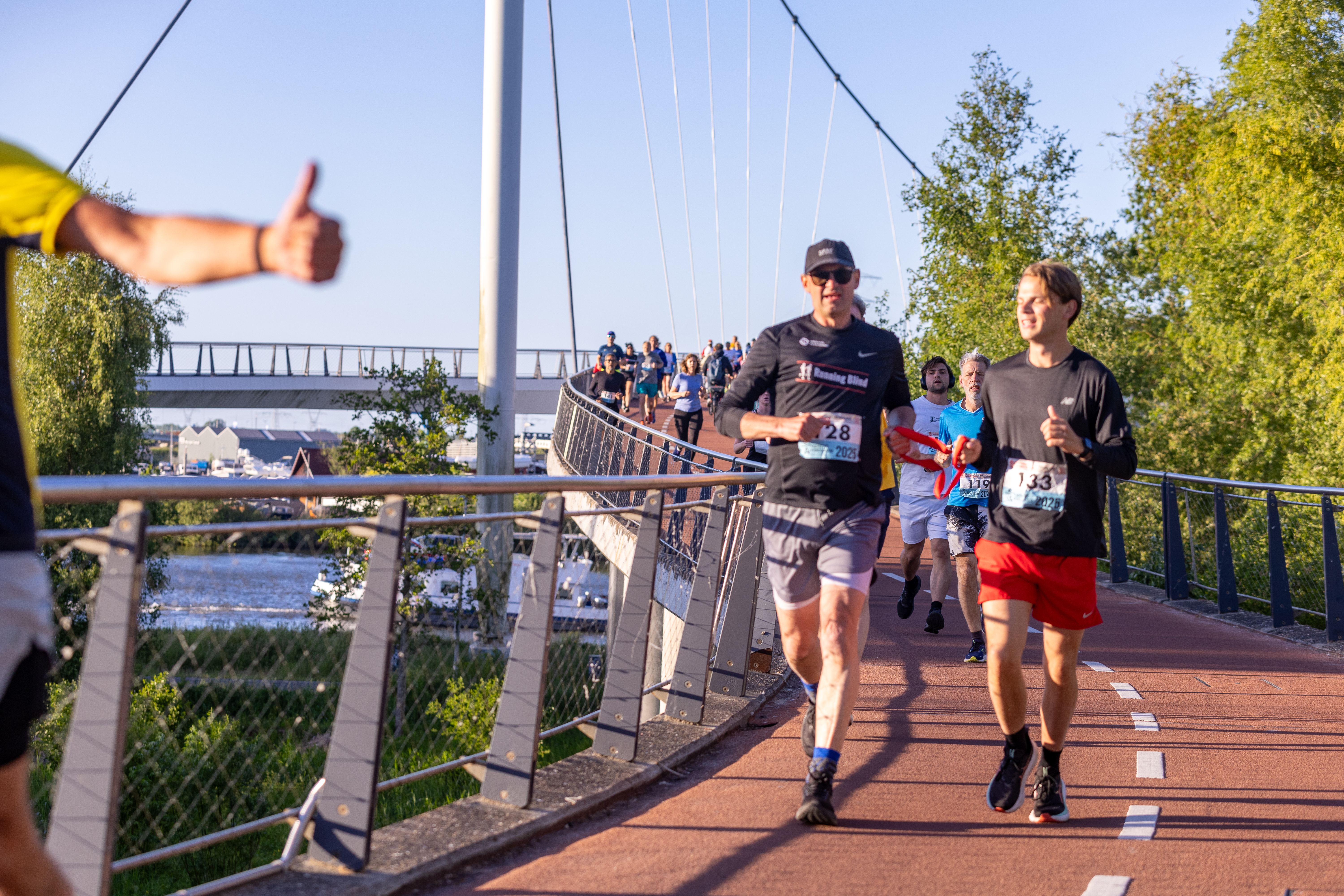 Hardlopers steken tijdens de route de Nesciobrug over.