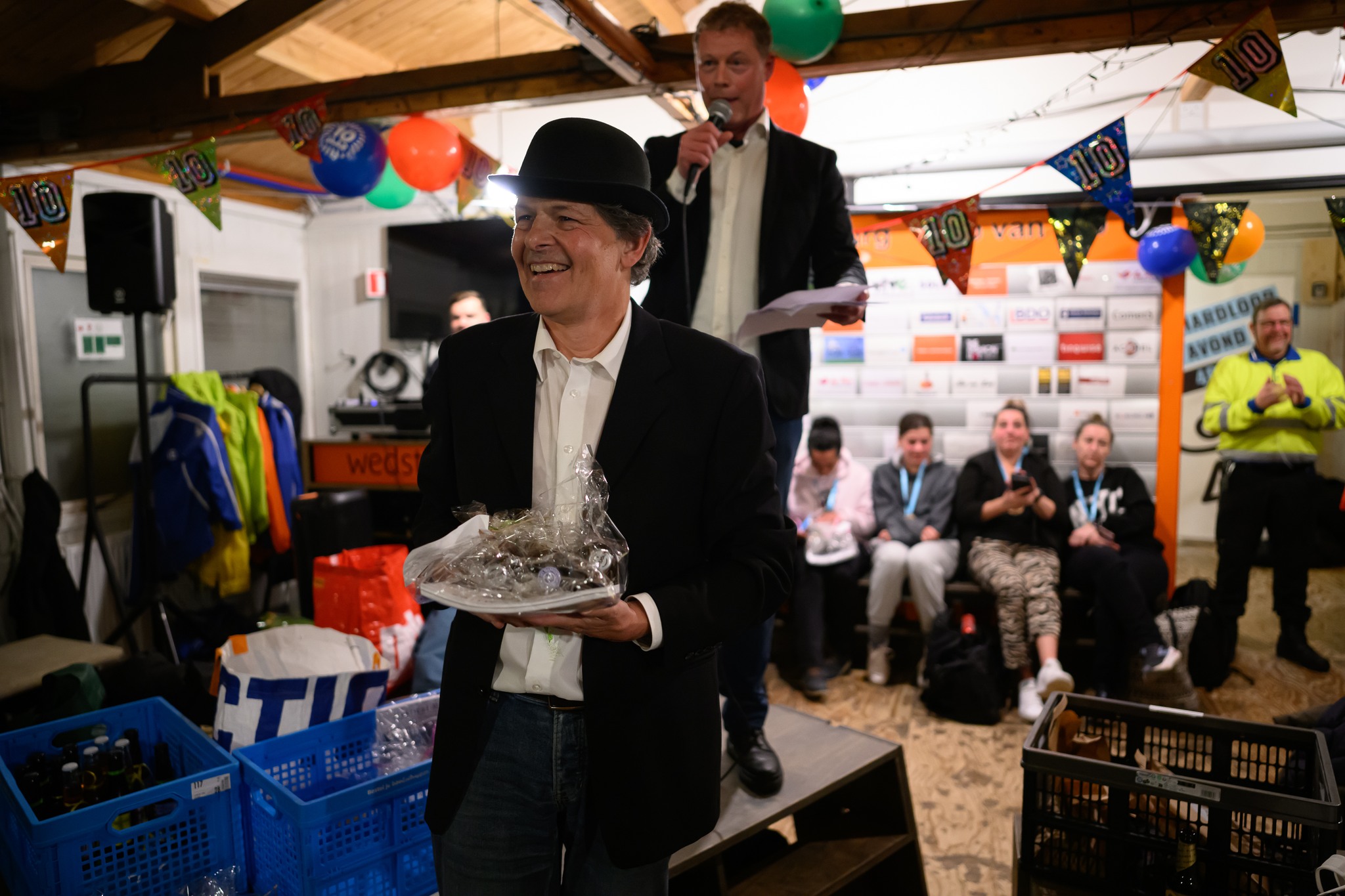 Een organisator ontvangt een onderscheiding tijdens het tienjarig jubileum van de Hardloopavond4daagse.