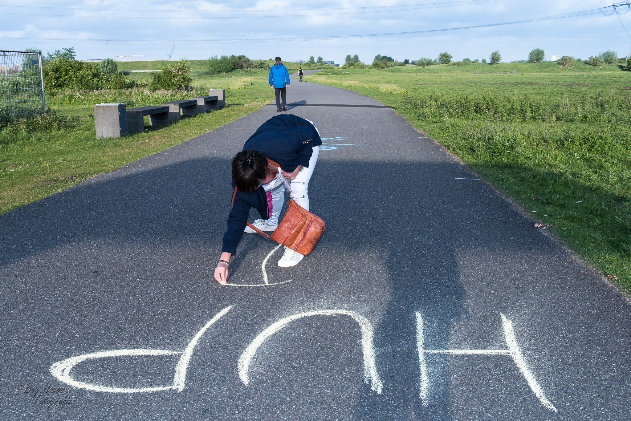 Een vrijwilliger schrijft &lsquo;HUP&rsquo; met krijt op het parcours om deelnemers aan te moedigen.
